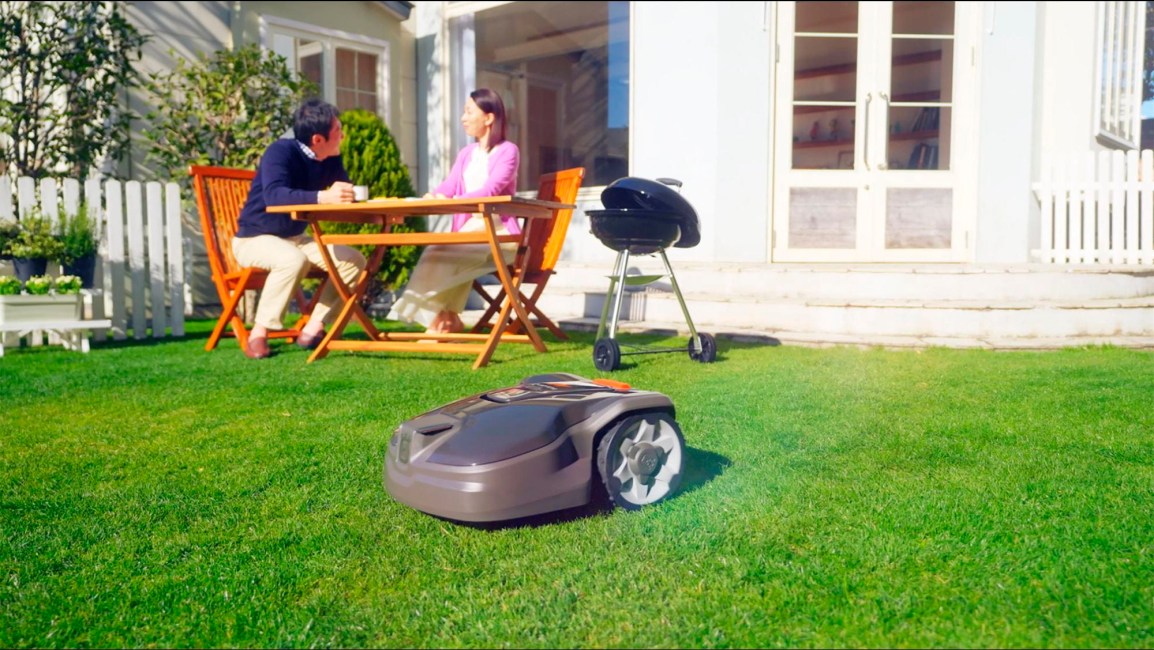 Couple enjoying lunch next to a Husqvarna Automower robotic mower